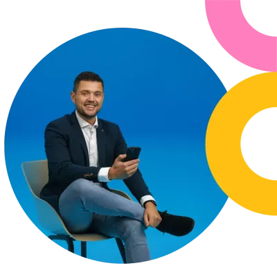 blue background guy sitting on chair with smartphone