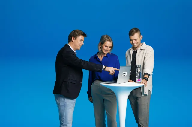 Personen schauen zusammen auf einen Laptop